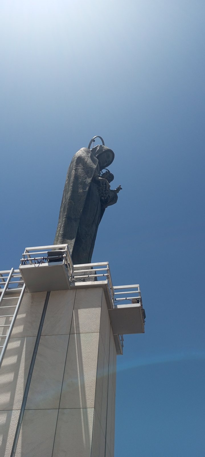 The bronze statue of Our Lady of Zahle atop her shrine tower, against the sky